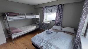 a bedroom with two bunk beds and a window at Ilulissat Apartment in Ilulissat
