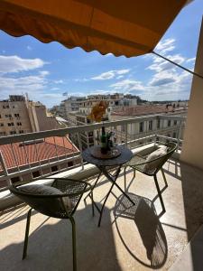 a table and chairs on a balcony with a view at 2 BD Apt in Syntagma with Acropolis view in Athens