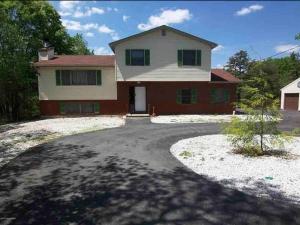 a large house with a driveway in front of it at Peaceful Pocono Home with Hot Tub, gym, & office in Long Pond