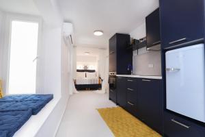 コルフ・タウンにあるCasa di Emilioのキッチン(黒いキャビネット付)、青いベッド1台が備わります。