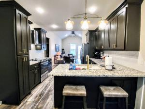 a kitchen with black cabinets and a counter with stools at Lakeview B - 10 Minutes to Oaklawn Racing & Gaming in Hot Springs