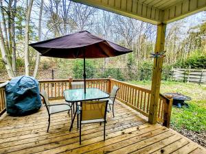 a table and chairs on a wooden deck with an umbrella at Lakeview B - 10 Minutes to Oaklawn Racing & Gaming in Hot Springs