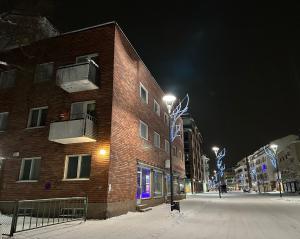 ein Gebäude in einer verschneiten Straße in der Nacht in der Unterkunft Arctic Apartment Rovaniemi in Rovaniemi