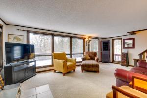 a living room with a tv and chairs and windows at Pet-Friendly Home with Deck 4 Mi to Jay Peak Resort in Montgomery Center