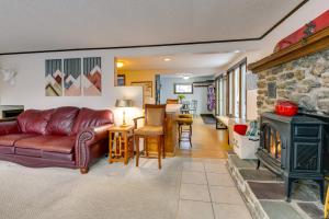 a living room with a leather couch and a fireplace at Pet-Friendly Home with Deck 4 Mi to Jay Peak Resort in Montgomery Center