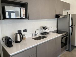 una cocina con fregadero y refrigerador en Ruka 9 Dpto 14 - Andarlibre, en San Martín de los Andes