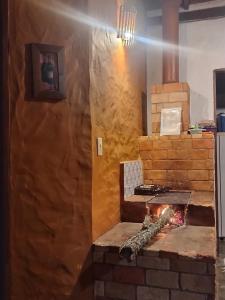 een bakstenen oven met een open haard in de keuken bij Pousada Chalé Terra Viva in Carrancas
