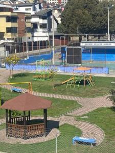 Suite Independiente e íntima al Norte de Quito في كيتو: حديقة مع ملعب مع منطقة لعب