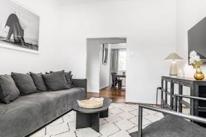 a living room with a gray couch and a table at La Playa Byron in Byron Bay
