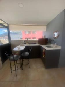 Suite Independiente e íntima al Norte de Quito في كيتو: مطبخ مع طاولة وكراسي ومغسلة