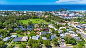 an aerial view of a suburb with the ocean at La Playa Byron in Byron Bay