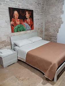 ein Schlafzimmer mit einem Bett und einem Wandgemälde in der Unterkunft Dimora Termite Pietà in Bitonto
