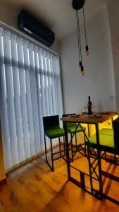 Un comedor con mesa y sillas y una gran ventana. en Apartman GreenPine, en Soko Banja 3 fotos más
