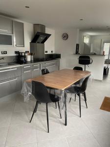 a kitchen with a wooden table and chairs at Douai à proximité in Flers-en-Escribeus +11 photos