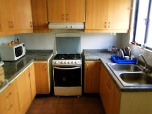 a kitchen with a stove and a sink at GUESTHOUSE MOUNTAIN TRAVEL ECUADOR 