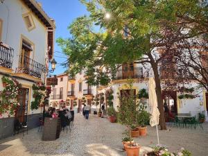 a street in a town with people sitting at tables at El Cantón Casa rural in Castril