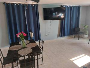 a dining room table with a vase of flowers on it at Casa Ciruelos Relax Confort and Relax in Ciudad Madero