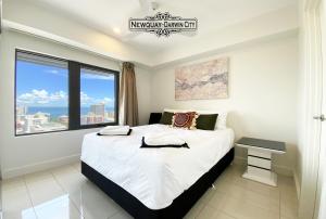 sypialnia z dużym łóżkiem i dużym oknem w obiekcie "NEWQUAY" Ideal Location & Views at PenthousePads w mieście Darwin
