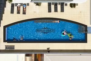 un panneau sur le côté d'un bâtiment avec des gens dans une piscine dans l'établissement "NEWQUAY" Ideal Location & Views at PenthousePads, à Darwin