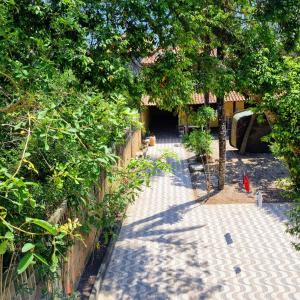 a garden with a fence and trees and a sidewalk at Casa Via Sol, Rio das Ostras in Rio das Ostras