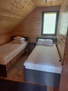 Duas camas num quarto com uma janela em Brvnare Libero TARA em Bajina Bašta