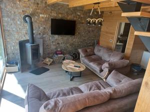 uma sala de estar com sofás de couro e uma lareira em Brvnare Libero TARA em Bajina Bašta