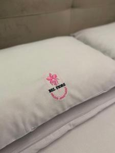 a close up of a white bedsheet with a pink flower on it at Bel Fiore Deluxe Apartment in Genova