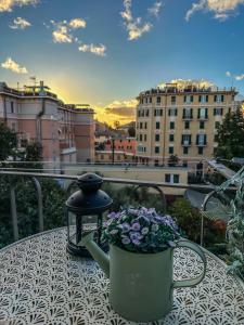 un tavolo con teiera e fiori sul balcone di Bel Fiore Deluxe Apartment a Genova