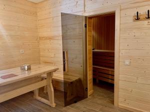 una sauna de madera con una mesa de madera y una puerta en Bilychi - садиба у Карпатах, en Bilichi