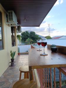 zwei Gläser Wein auf einem Holztisch in der Unterkunft Luna Lodge in Fortuna