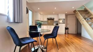 a kitchen and dining room with a table and chairs at Cool new Notting Hill apt - 2 mins to Portobello in London