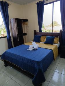 1 dormitorio con 2 camas y toallas. en Luna Lodge en Fortuna