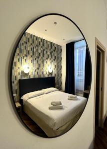 una camera da letto con un letto con uno specchio rotondo di La Grande Bellezza Guest House Rome a Roma