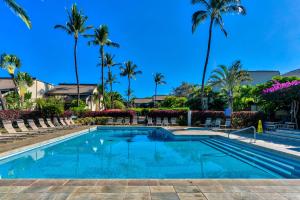 a swimming pool at a resort with palm trees at Maui Kamaole in Wailea