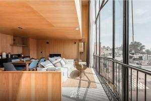 a living room with a white couch and chairs on a balcony at DIB Collection in Mexico City