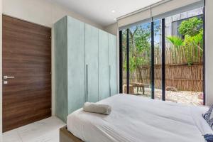 a bedroom with a large bed and a large window at Kite 101 in Tulum +13 photos
