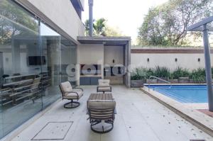 un patio con sillas y una piscina en Cozy Villa Morra Apt, en Asunción