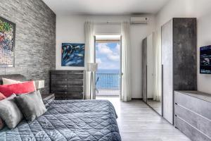 1000 Suites في نابولي: غرفة نوم مع سرير وإطلالة على المحيط