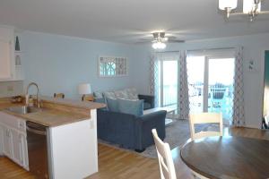 eine Küche und ein Wohnzimmer mit einem Sofa und einem Tisch in der Unterkunft Living the Dream on the beach! in Carolina Beach