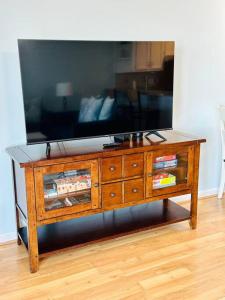 a wooden entertainment center with a flat screen tv on top at Living the Dream on the beach! in Carolina Beach