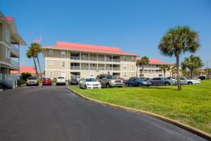 a parking lot with cars parked in front of a building at Sunset Harbor Villas #4-421 in Navarre