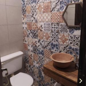 uma casa de banho com lavatório, WC e azulejos em ENCUENTRO LA ÑATA em Amaicha del Valle