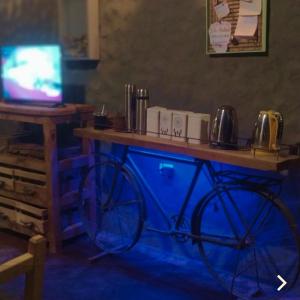 einen Tisch mit einem aokedokedoked Bike in einem Zimmer mit einem TV in der Unterkunft ENCUENTRO LA ÑATA in Amaichá del Valle