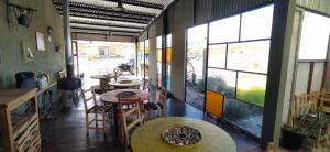 a room with tables and chairs and large windows at ENCUENTRO LA ÑATA in Amaicha del Valle