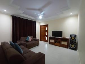 a living room with a couch and a television at CHÁCARA BARBOSA II in Socorro