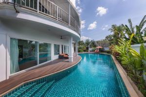 a swimming pool in the backyard of a house at Villa Sirion in Kamala Beach