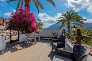 a patio with pink flowers and a table and chairs at Las Casas de la Rueda - El Patio in Santa Lucía