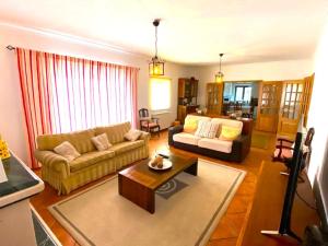 een woonkamer met een bank en een salontafel bij Villa very quiet, fantastic views, ideal for families, fun and relaxation. in São João da Ribeira