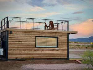 a small building with a balcony on top of it at New The Cowboy Boots-Shipping Container Home in Alpine