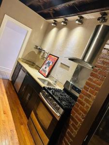een keuken met een fornuis en een bakstenen muur bij Two bedroom excellent location in Queens
